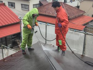 屋根の高圧洗浄をする職人達